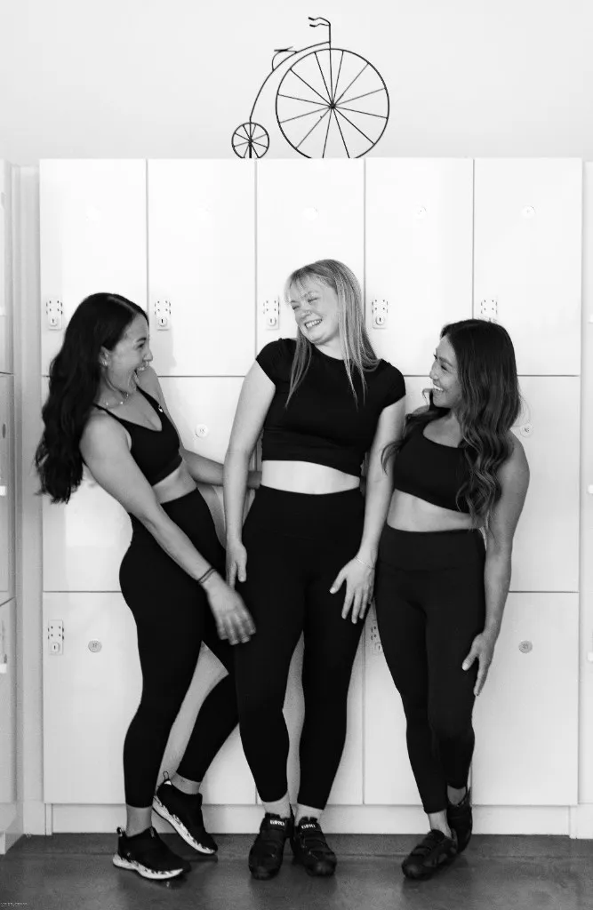 SpinHouse riders laughing together in black and white