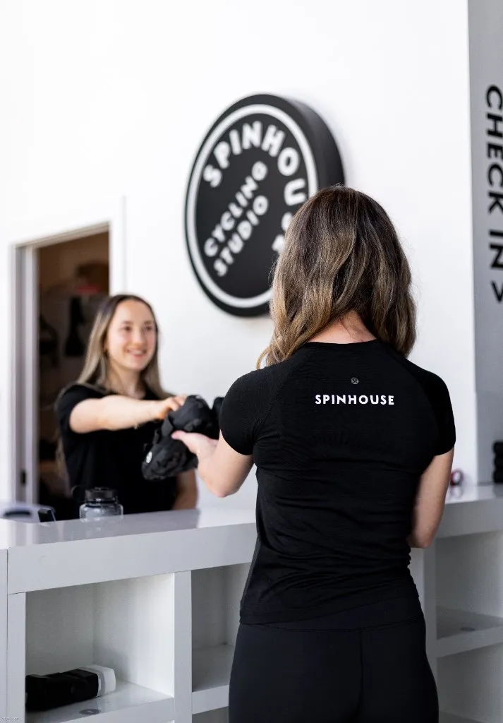 A SpinHouse team member welcoming a rider at the front desk
